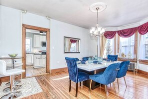 A dining room with a wooden table set for six, blue velvet chairs, and a chandelier. - Front Royal Retreat ~ 1 Mi to National Park! (Front Royal)