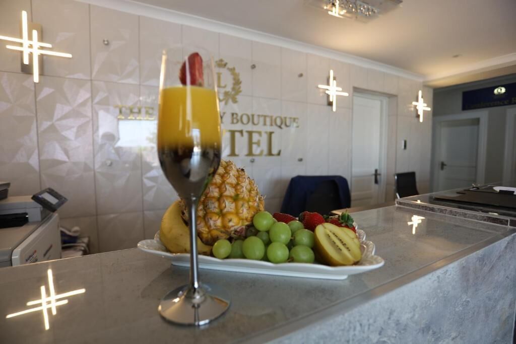 A reception area with a fruit platter and a glass of orange juice on a marble counter.