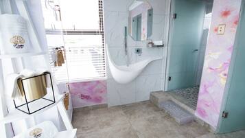 Un baño moderno con una bañera independiente, un tocador con espejo y una zona de ducha.