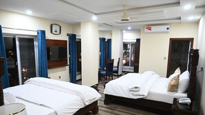 A hotel room with two beds, a TV, a clock, and an air conditioning unit. - Hotel 99 (Rawalpindi)