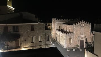 Un bâtiment historique en pierre, doté d’une tour et d’une cour intérieure.