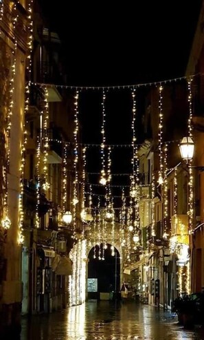 A street at night with string lights and lanterns. - Casa Fresta (Taormina)