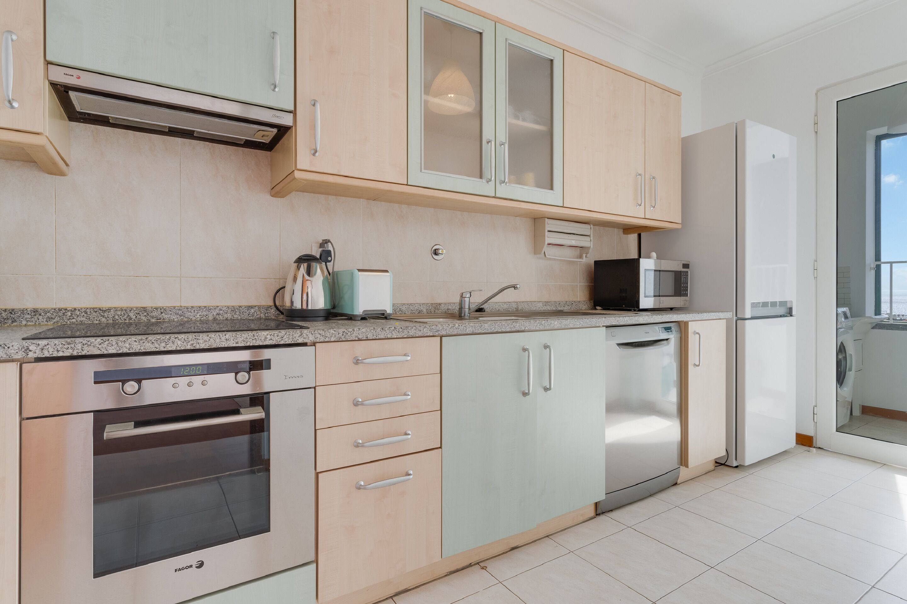 A modern kitchen with a built-in oven, microwave, and dishwasher.