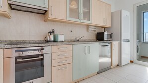 A modern kitchen with a built-in oven, microwave, and dishwasher. - Camara de Lobos Apartment (Camara de Lobos)