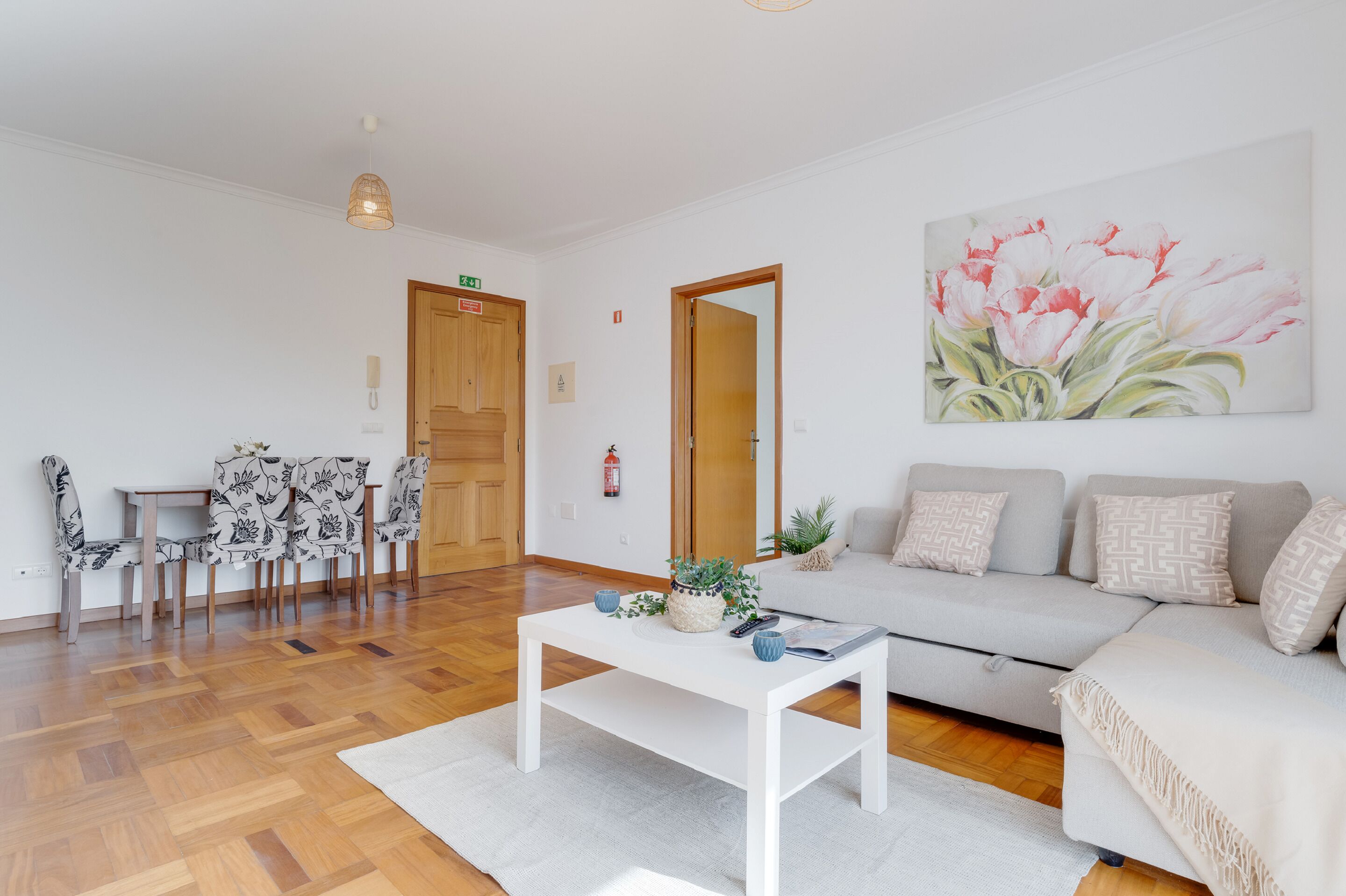 Una sala de estar moderna con un sofá, una mesa de centro y un comedor con sillas y una mesa.