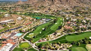 An aerial view of a golf course with a mountainous backdrop, surrounded by residential areas and a few buildings. - Nomad Gamer Pad- A Mountain Reserve Home w/ Pool, Spa, Esports Arena & Squat Gym (Phoenix)