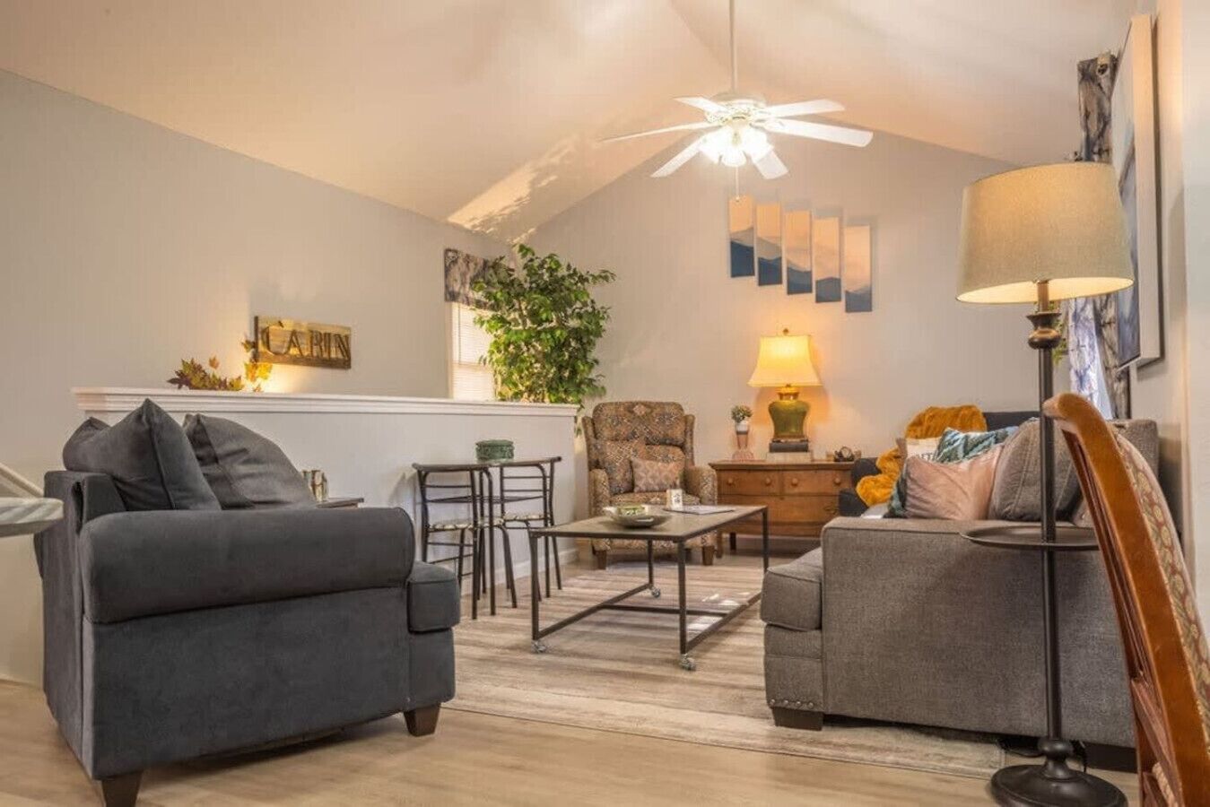 A living room with two sofas, a coffee table, a lamp, and a ceiling fan.