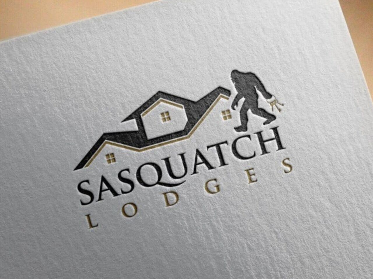 Un logo représentant une maison stylisée et une silhouette en train d’escalader, symbole de SASQUATCH LODGES.