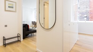 Een modern interieur met een ronde spiegel, een bank en een eethoek.