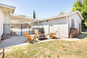A patio with outdoor furniture, a fire pit, and a small shed. - Misha’s HunnCottage (Yuba City)