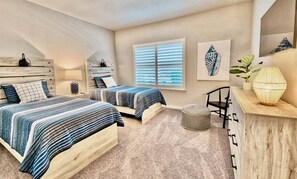 A bedroom with two beds, a wooden headboard, a window with blinds, a bedside table with a lamp, and a wall-mounted mirror. - Bayside * 20008 * NEW Luxury Home * 5 BR *4.5 Bath (Selbyville)