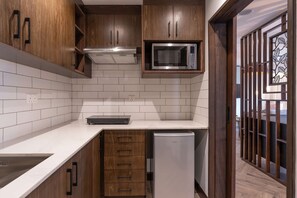 A modern kitchen with wooden cabinets, a built-in microwave, and a refrigerator.