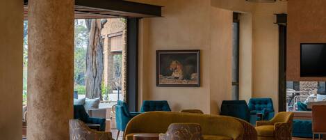 A spacious lobby with a large column, multiple seating areas, and a television.