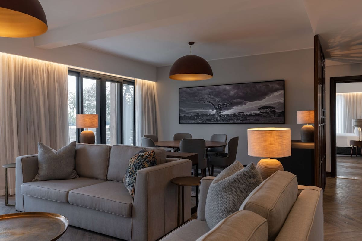 Un salon moderne avec un canapé, des lampes et un coin repas.