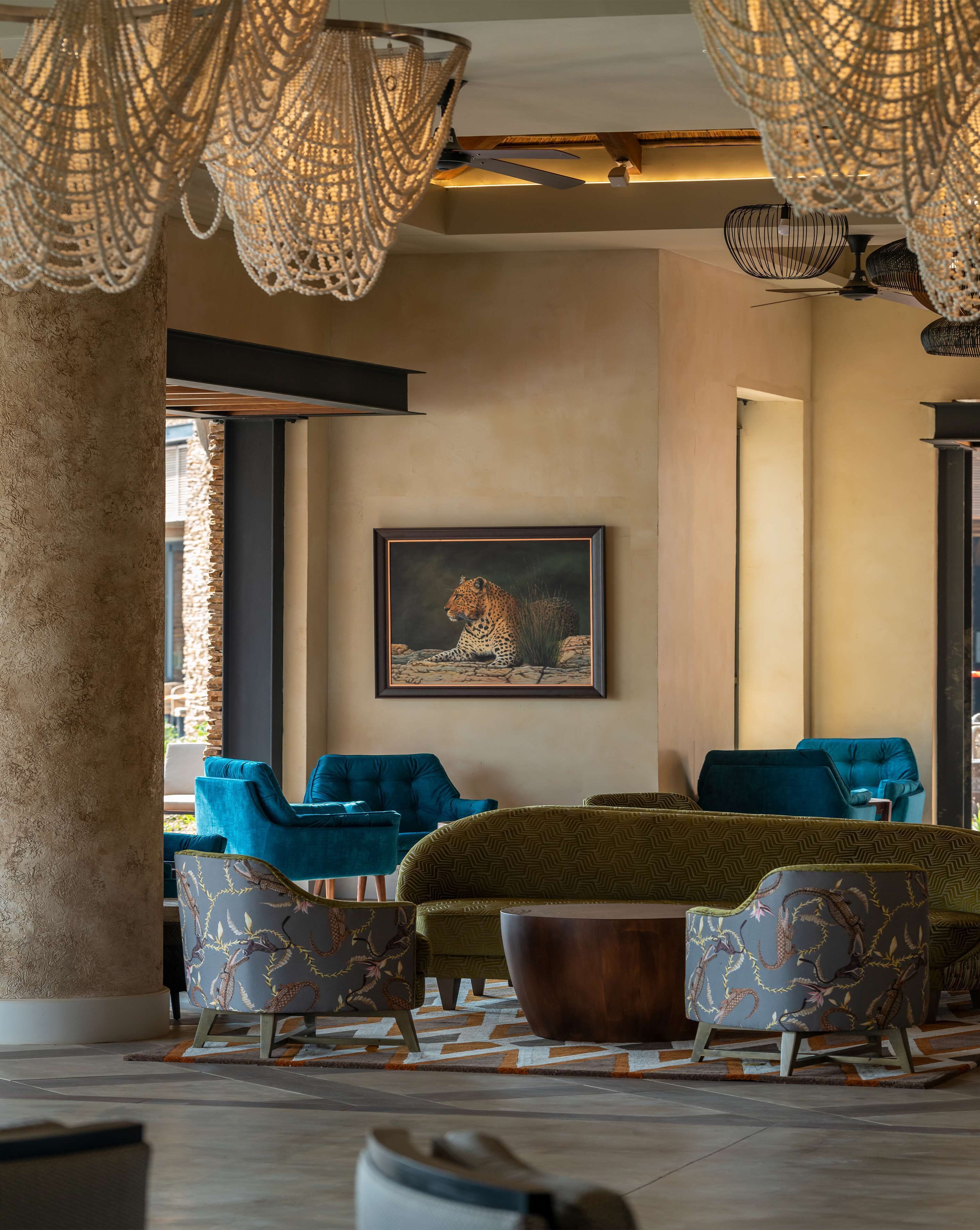 A modern lobby with a large seating area, a ceiling fan, and a framed artwork on the wall.