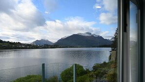 A lake with mountains in the background, viewed from a window with a metal railing in the foreground. - Frankton House - Queenstown Holiday Home (Queenstown)