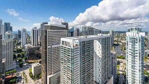 A high-rise urban area with modern buildings, a clear sky, and a river in the background.