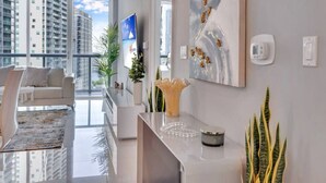 A modern living room with a sofa, a coffee table, and a view of high-rise buildings.