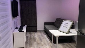 A modern living room with a sofa, a coffee table, a TV, and a sign that reads "Casa Jacinto Welcome".