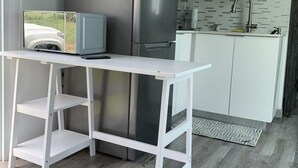 A modern kitchen with a stainless steel refrigerator, white cabinetry, and a built-in microwave.