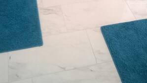 A bed with a teal bedspread, two blue area rugs, and a white tiled floor. - Apartment in Zaton (Zadar) with Seaview, Balcony, Air condition, WIFI (685-2) (Nin)