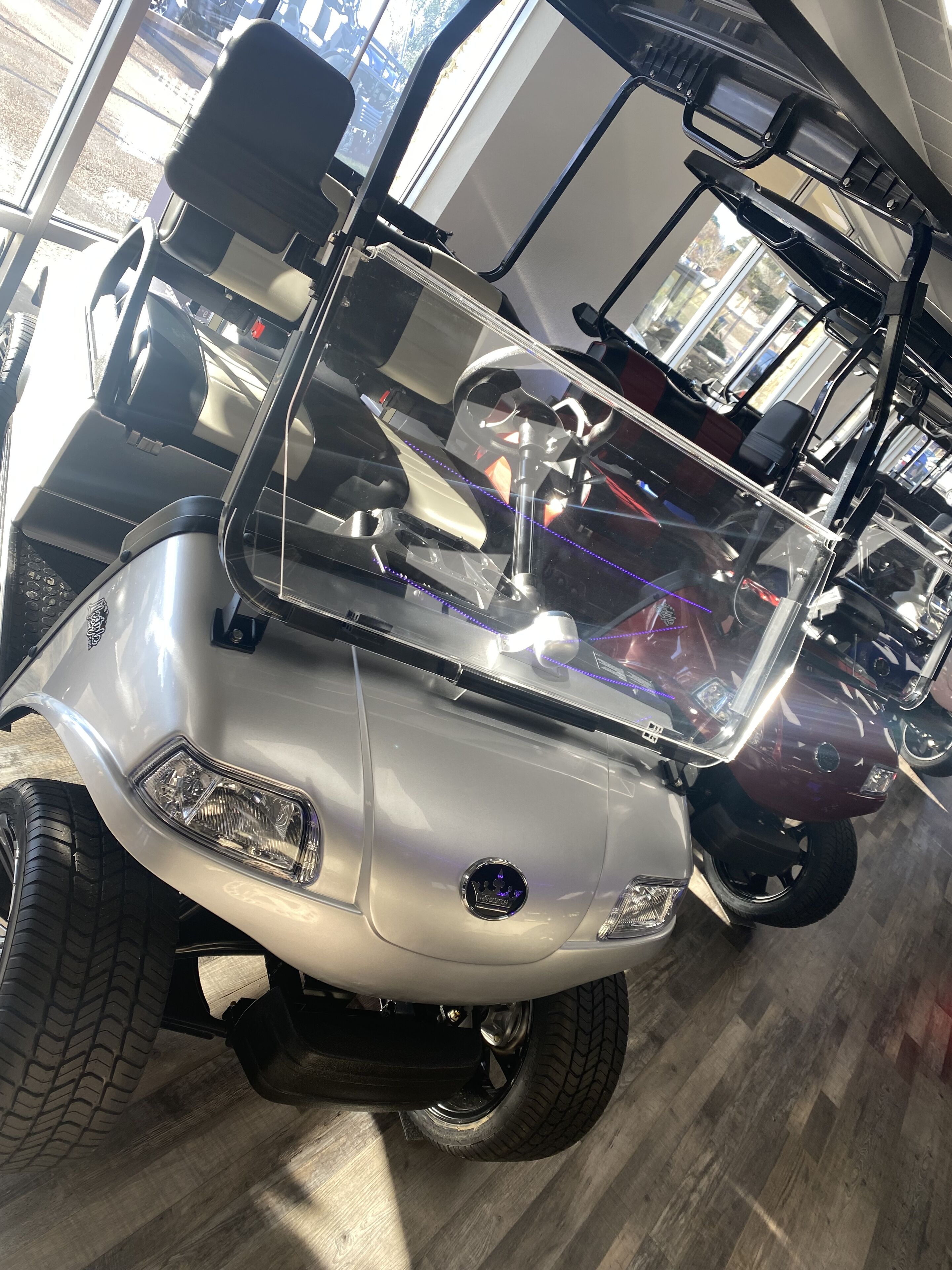 A vehicle with a windshield, side mirrors, and a logo on the front.