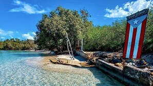 Una playa despejada con una torre de salvavidas y un letrero con una estrella.