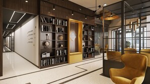 A modern library with bookshelves, a seating area, and a decorative wall. - Bob W Tartu Old Town (Tartu)