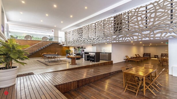 A spacious indoor area with a wooden floor, a staircase, and a decorative wall. - Alure by Kukun (Mexico City)