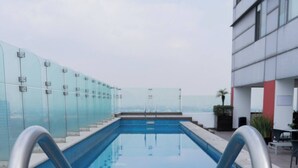 A modern pool with metal railings, surrounded by glass railings and a wooden deck. - 1BR|1BA Apartment W/ pool, gym, high speed WiFi, located just a 3-minute walk from the new U.S. Embassy (Ciudad de México)