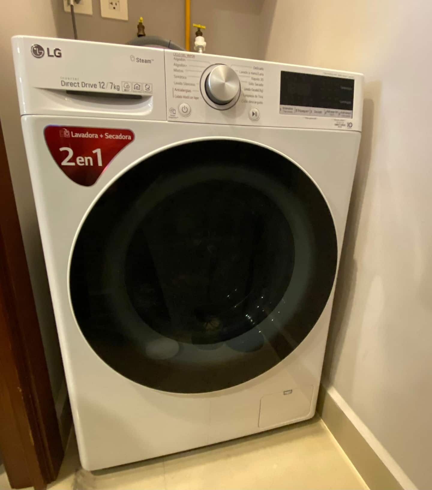 A front-loading LG Direct Drive 12 kg washer with a 2 en 1 label, indicating it has two washing machines and one dryer.