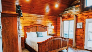 A wooden-paneled bedroom with a bed, a nightstand, and a dresser. - Firefly Treehouse - Starlight Haven (Hot Springs)