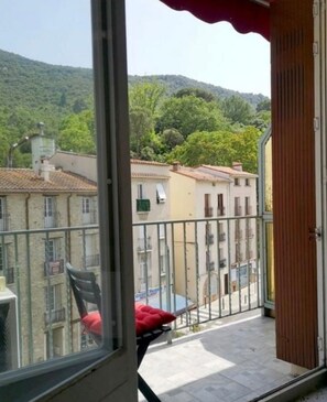 Un balcon donnant sur un quartier résidentiel et des collines.