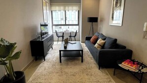 Un salon moderne comprenant un canapé, une table basse et un coin repas avec des chaises et une table.