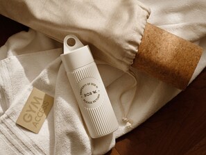 A white water bottle with text, a brown cork, and a white towel with a tag. - Bob W Florence Ponte Vecchio (Florence)