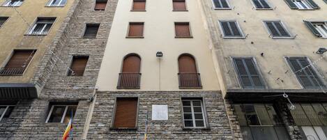 A multi-story building with stone facades and multiple windows.