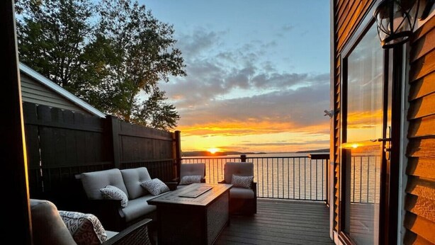 Una terraza con sofá y sillones orientados hacia la puesta de sol.