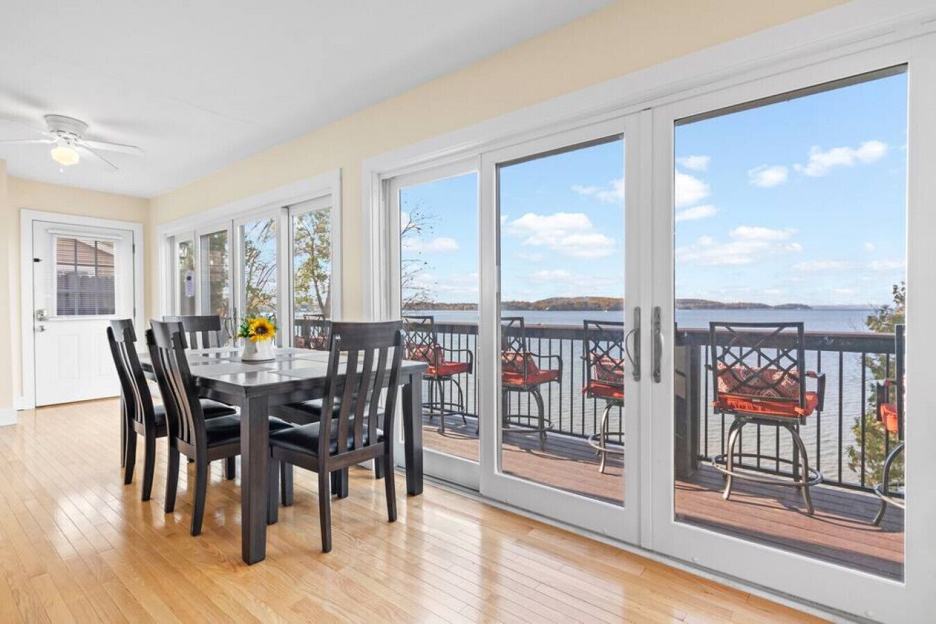 A dining area with a table and chairs, large sliding glass doors leading to a balcony with outdoor seating.