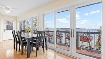 A dining area with a table and chairs, large sliding glass doors leading to a balcony with outdoor seating.
