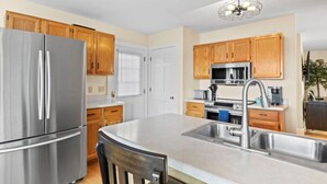 Una cocina moderna con electrodomésticos de acero inoxidable, armarios de madera y una isla grande con fregadero.