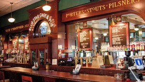 A bar with wooden decor and a menu board for draft beers.