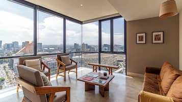 Un amplio espacio de sala con ventanas grandes, una mesa de centro de madera y asientos cómodos.