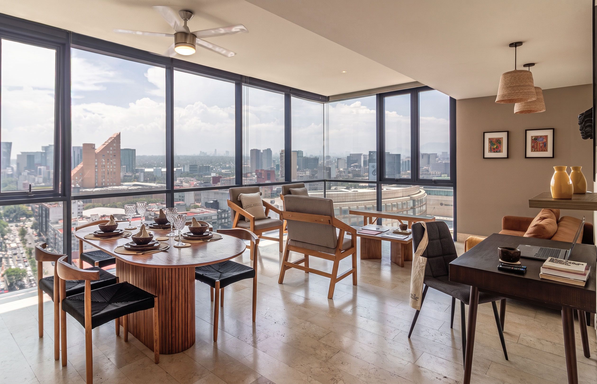 Un interior moderno con comedor, asientos y vista a la ciudad.