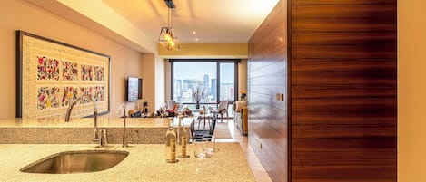 A modern kitchen with a granite countertop, stainless steel sink, and wooden cabinetry.