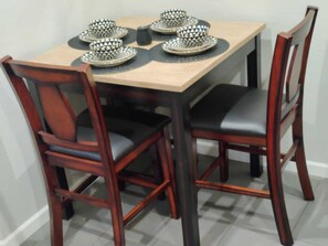 A dining table with four chairs, each with a black seat cushion and a wooden frame. - Sports fans & Foodies King with Balcony, Queen, pool minutes to Golf & Airport  (Phoenix)
