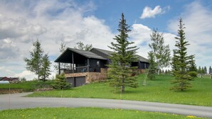 A modern house with a stone exterior, a balcony, and a driveway. - Stunning Gallatin Gateway Mountain Retreat! (Gallatin Gateway)