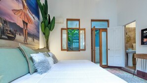 A bedroom with a large bed, a painting, a plant, and a view of the outside. - Arias Room Nº 5 (Ciudad de Panamá)