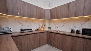 A modern kitchen with wooden cabinets, a marble backsplash, and built-in appliances. - AMAZING Location with Pool and Rooftop  A13 (Ciudad de Panamá)