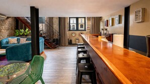 A bar area with stools, a wooden counter, and a view of a staircase leading to an upper floor. - Ecleptic apartment with 4 rooms and amazing pool (Ciudad de Panamá)