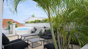 A rooftop terrace with a hot tub, outdoor seating, and lush greenery. - Renovated Apartment with Balcony in Casco Viejo M8 (Ciudad de Panamá)